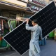 A worker carrying a solar panel at a market in Lahore, June 2024] Image Source: CNN, Photo By: Arif Ali/AFP/Getty Images